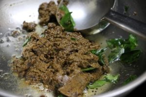 sauteing ground paste in oil for pepper kulambu