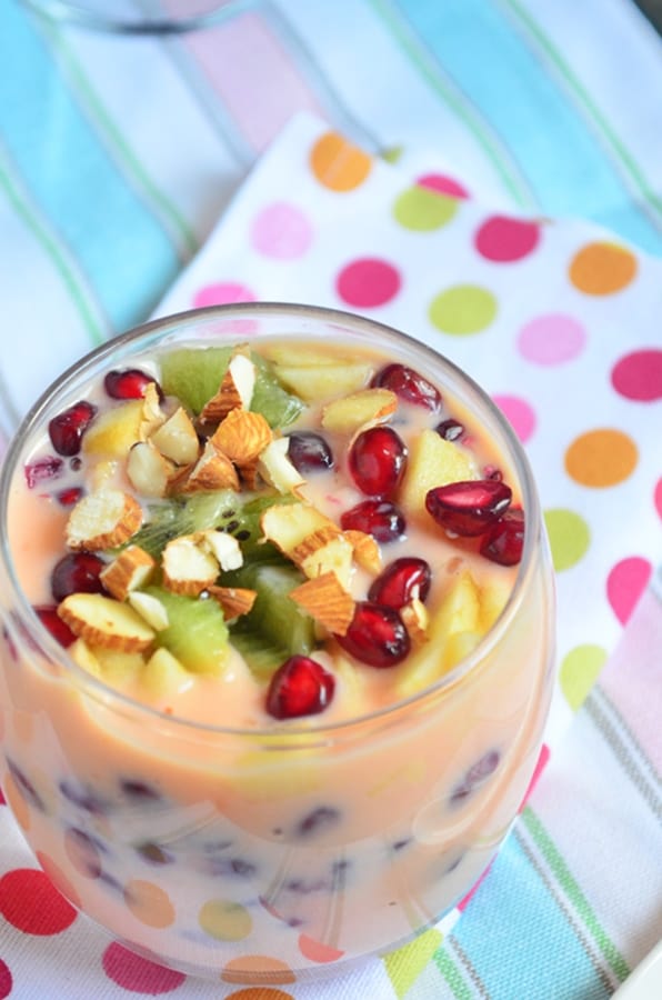Fruit custard served with nuts in a dessert glass