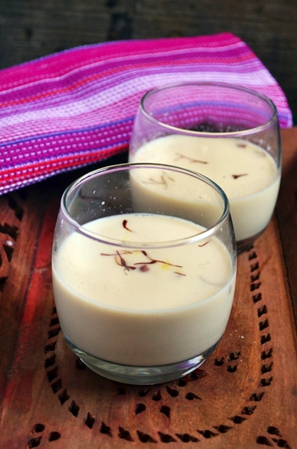 homemade thandai served in short glasses on a wooden tray