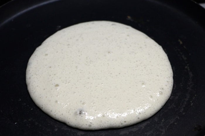 dosa batter poured over hot tawa
