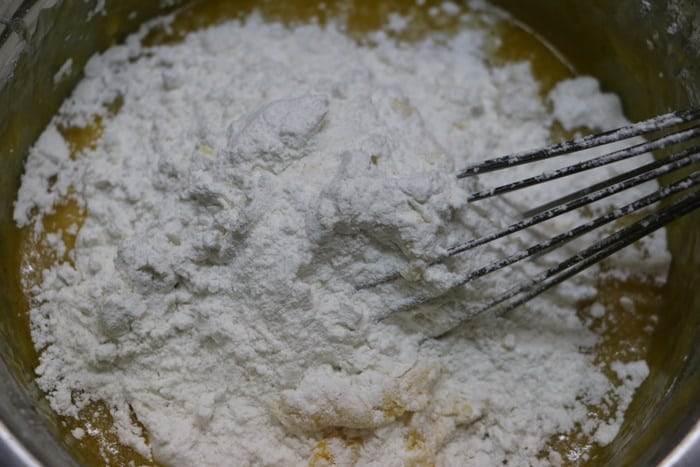 flour added to wet ingredients for making mango cake recipe