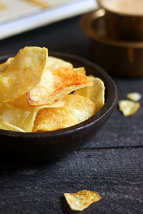 Crispy homemade potato chips in a black pottery bowl.