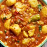 closeup short of Indian vegan potato curry in a green enamel pan.