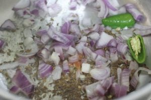 sauteing onions, green chilies and cumin seeds in oil