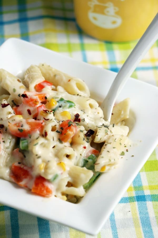 Creamy white sauce pasta served with a spoon