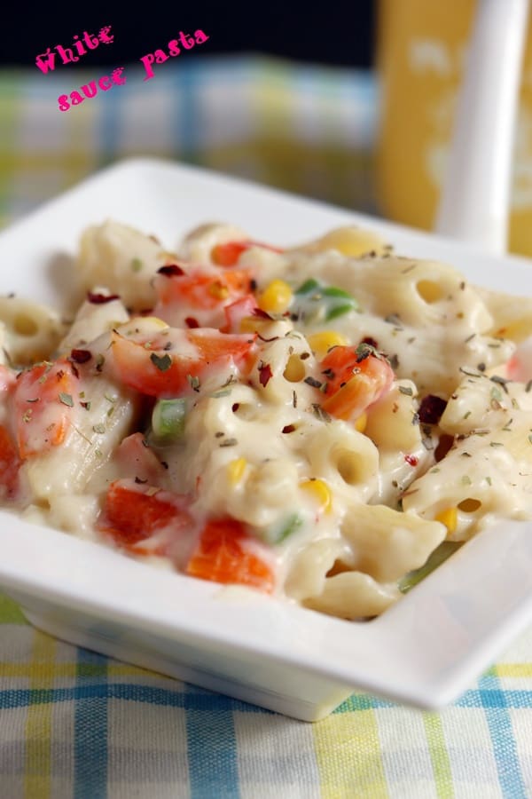 Creamy white sauce pasta served in a ceramic white dish.