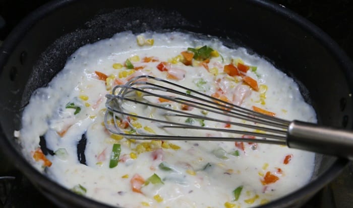 Adding veggies to the white sauce