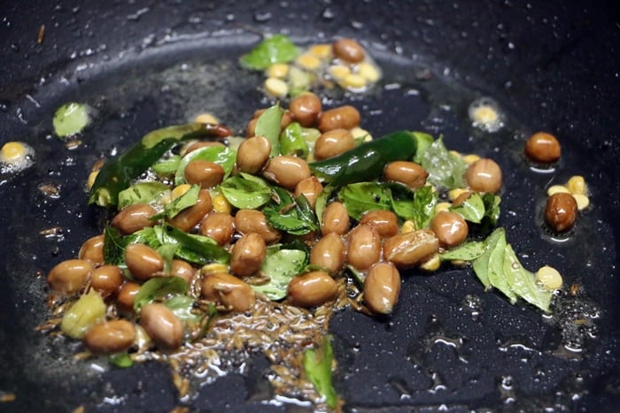 frying mustard seeds, cumin seeds, curry leaves and green chillies in oil- tempering for poha