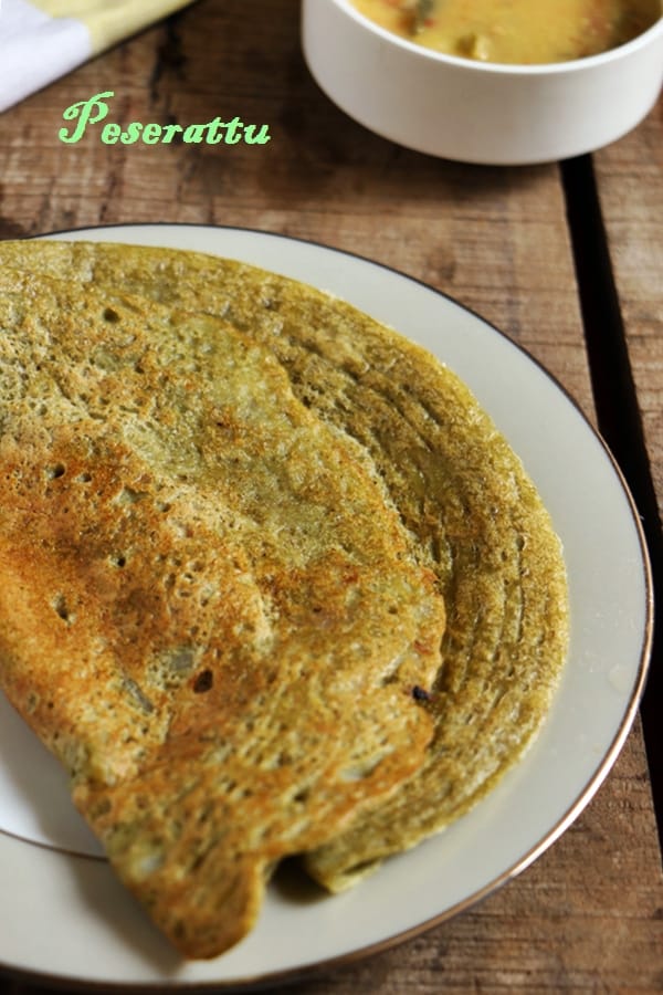 crispy pesarattu in a white ceramic plate with sambar in background