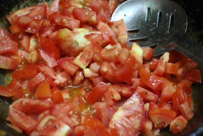 cooking chopped tomatoes in oil for pickle