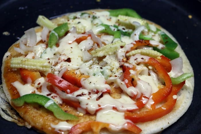Dosa pizza- making of easy dosa pizza with vegetables and cheese.