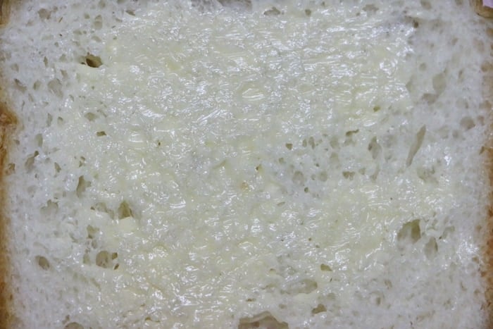 spreading butter on bread slices for making bombay veg sandwich recipe