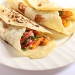 two homemade vegetarian fajitas placed on a ceramic plate.