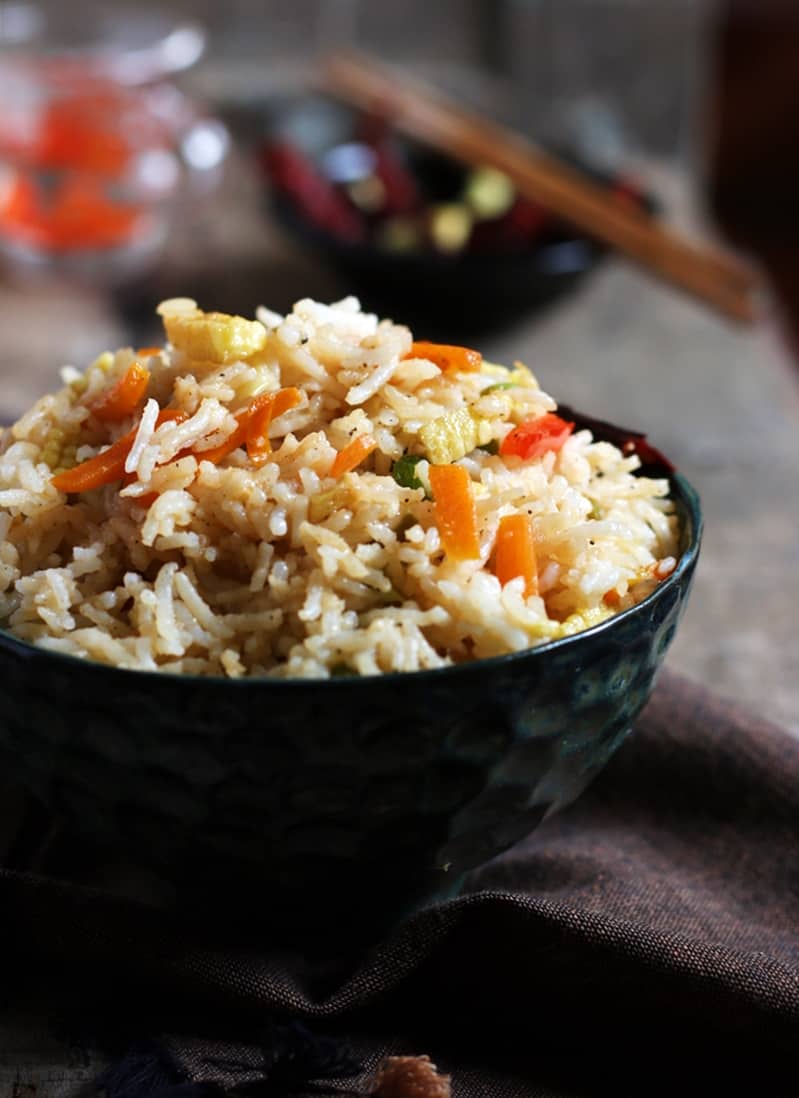 A bowl of spicy homemade Singapore fried rice served with chop sticks