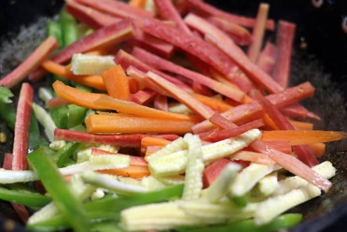 Adding vegetable batons for making vegetable jalfrezi recipe