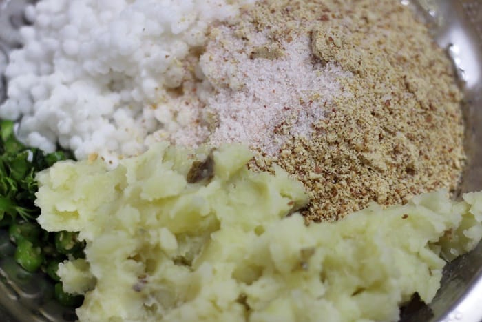 soaked and drained sabudana, mashed boiled potatoes, coarse powder of peanuts and salt in a mixing bowl for making sabudana vada