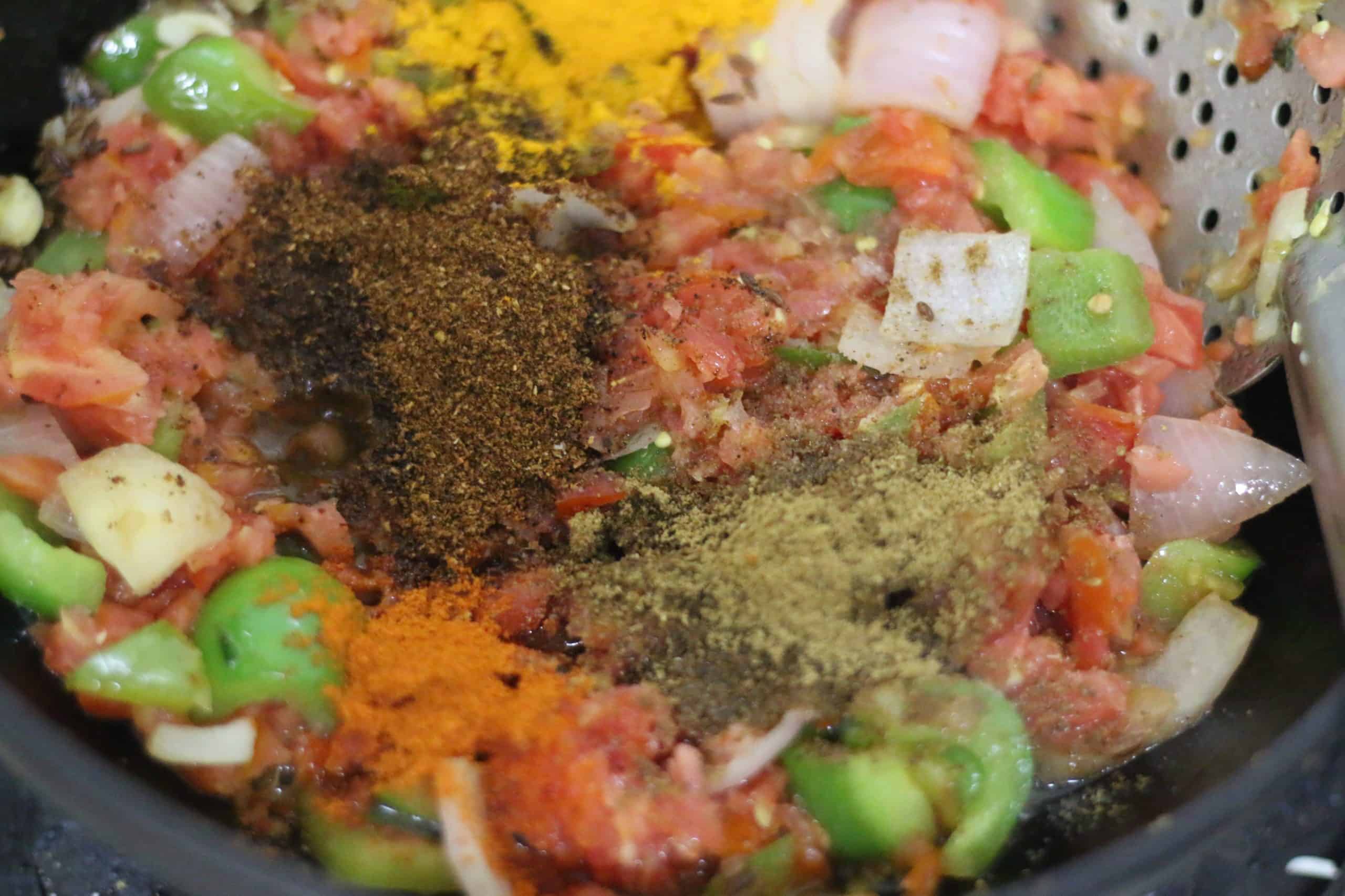 kadai masala, garam masala added to onion tomato base for kadai paneer recipe