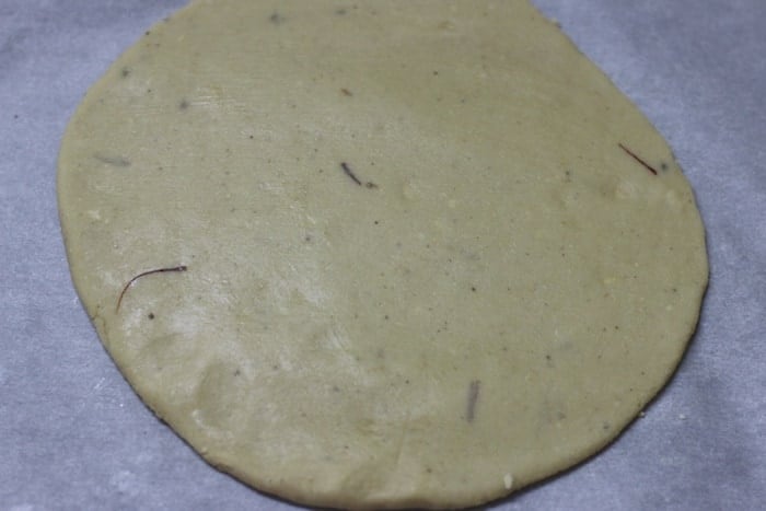 cashew dough rolled into a thin circle using rolling pin.