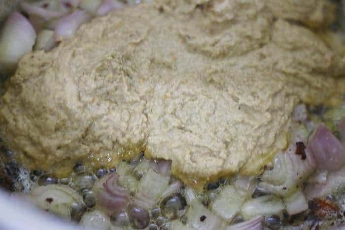 adding fresh spice paste to the oil for making vegetable korma