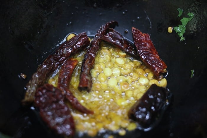 frying chilies and chana dal in sesame oil for making chutney