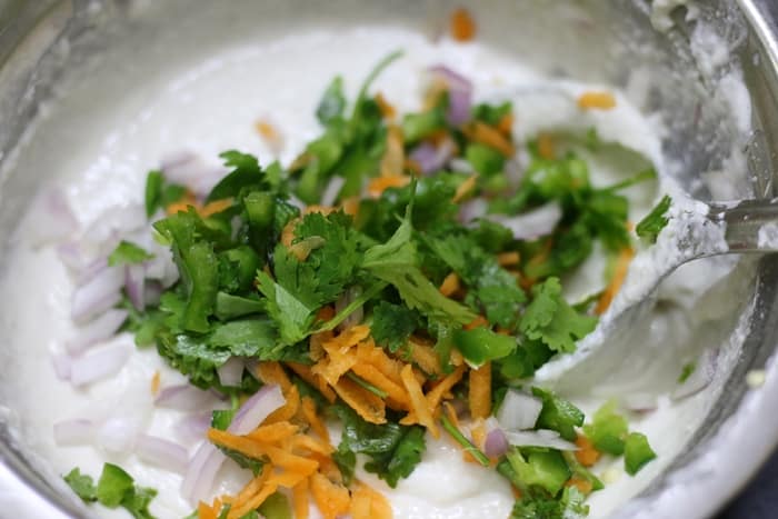 adding veggies to the batter for punugulu recipe