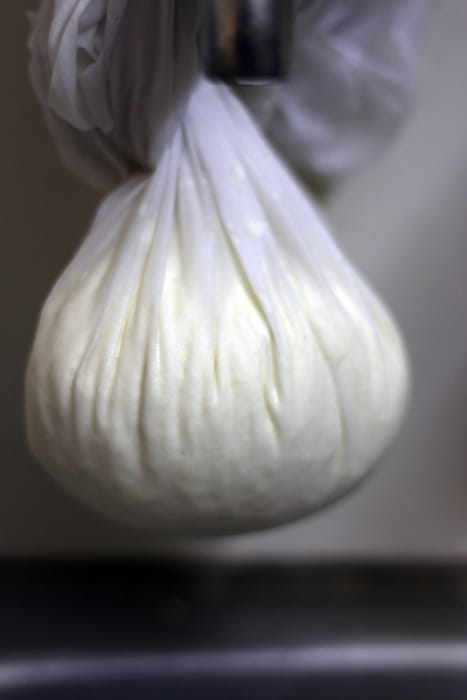 Hanging the curdled milk to remove whey