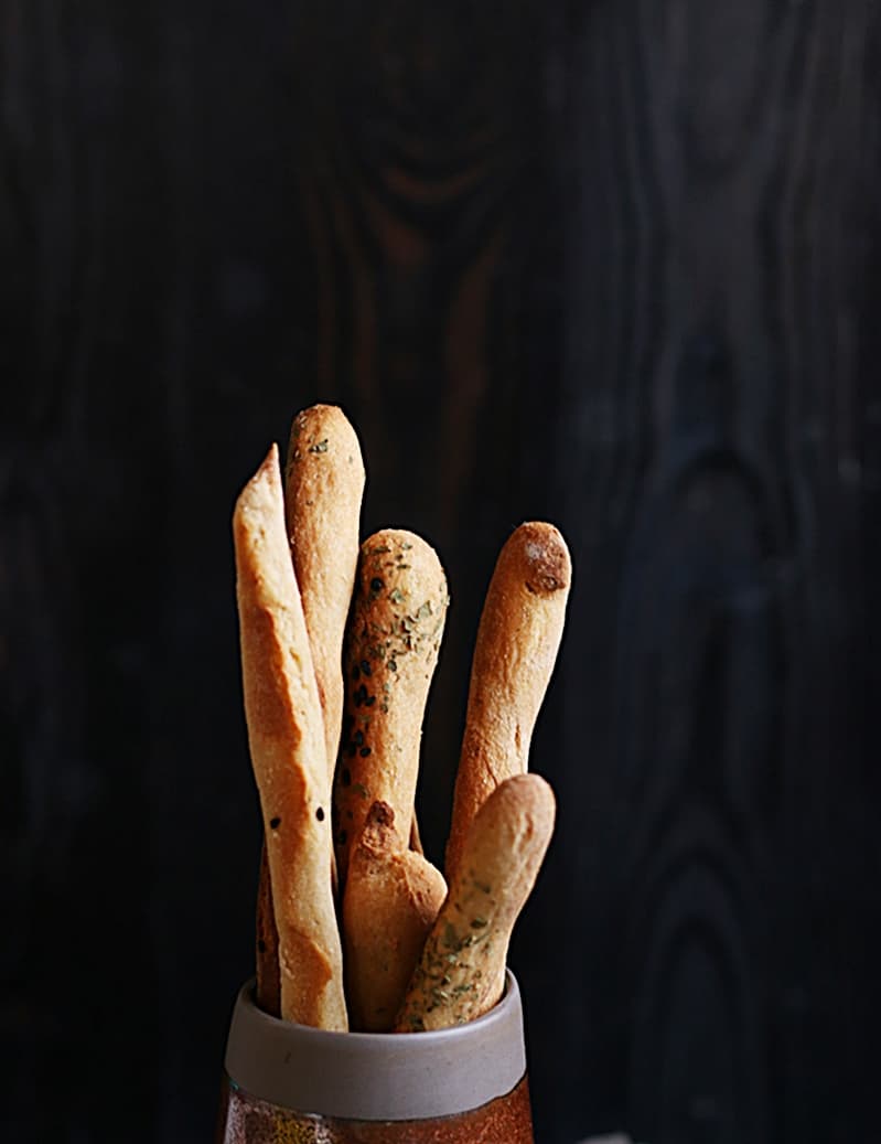 homemade bread sticks served in a small cup with dip