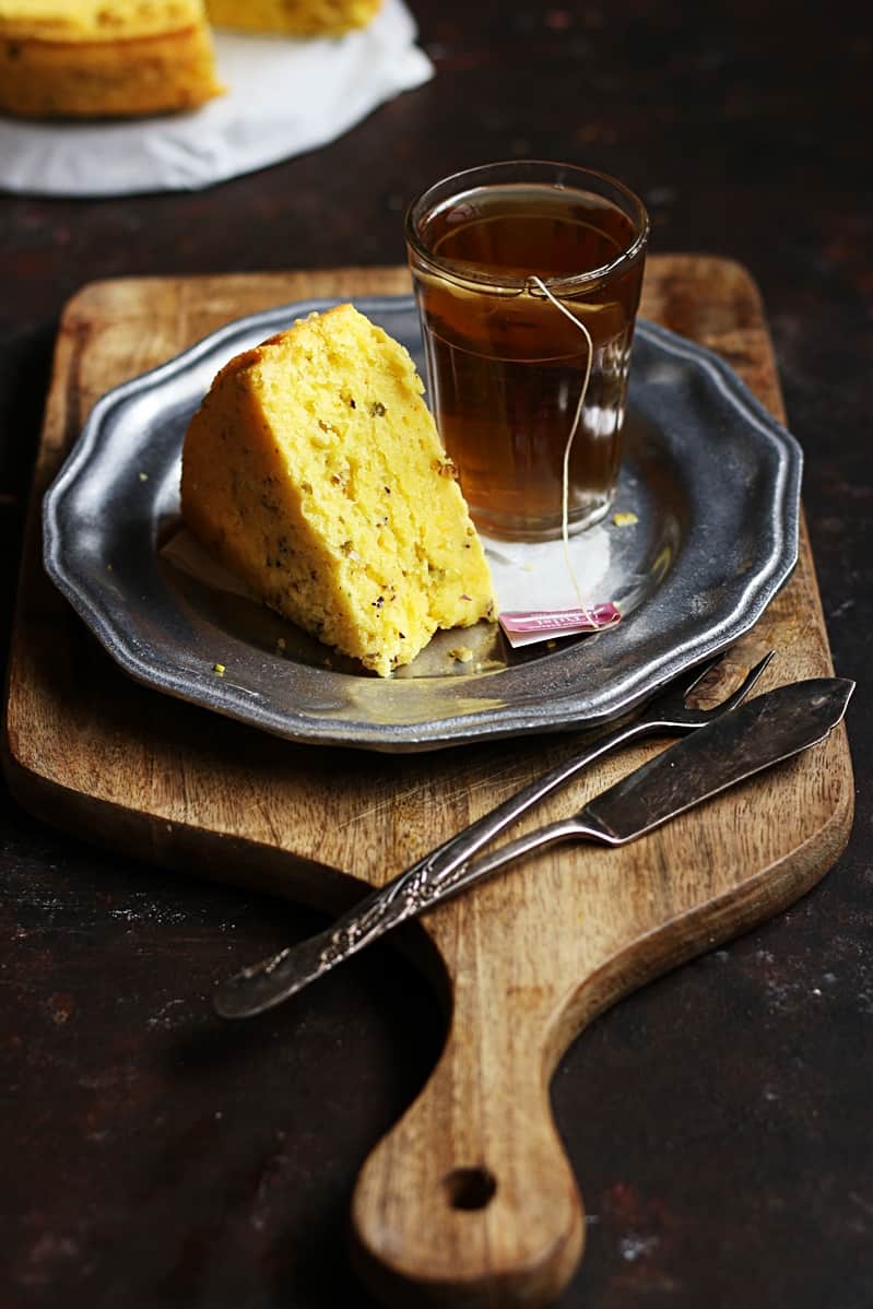 eggless mawa cake sliced and served with tea on a serving board