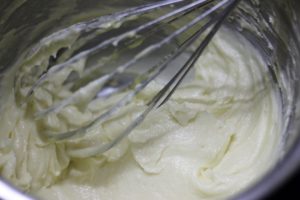 Mixing wet ingredients with dry ingredients for mawa cake
