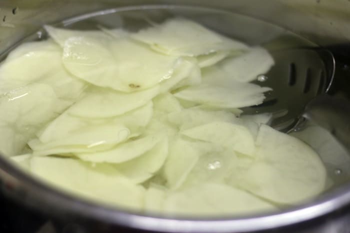 sliced potatoes soaked in water