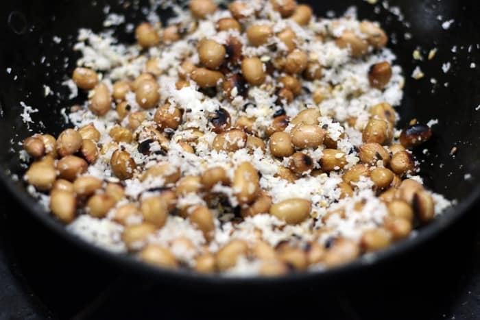 Roasting coconut and peanuts for making bharli vangi recipe