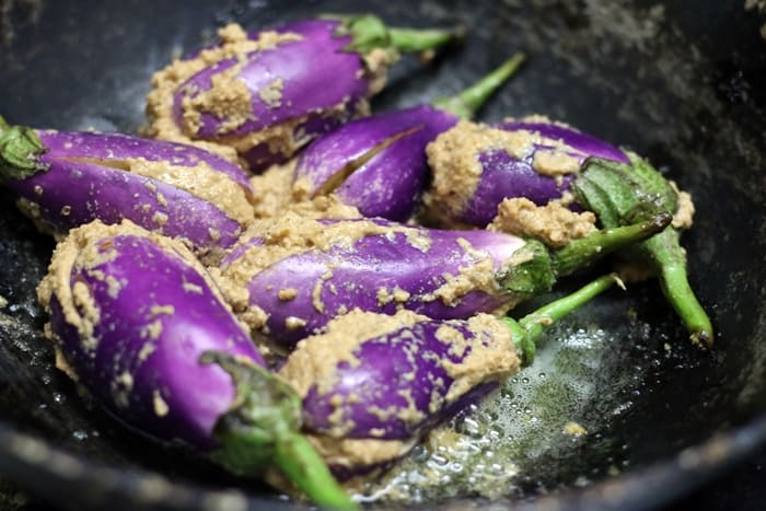 Sauteing stuffed eggplants for making bharli vangi recipe