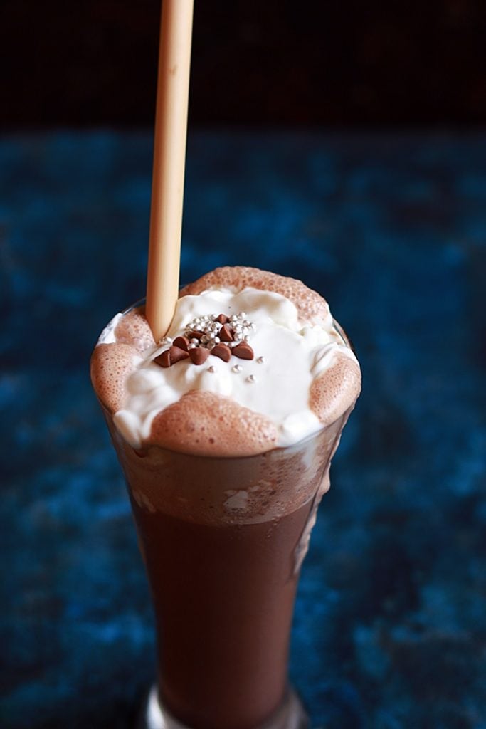 Homemade thick chocolaye milkshake served with bamboo straw