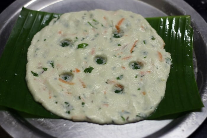 Spreading rice flour ball intp roti with fingers