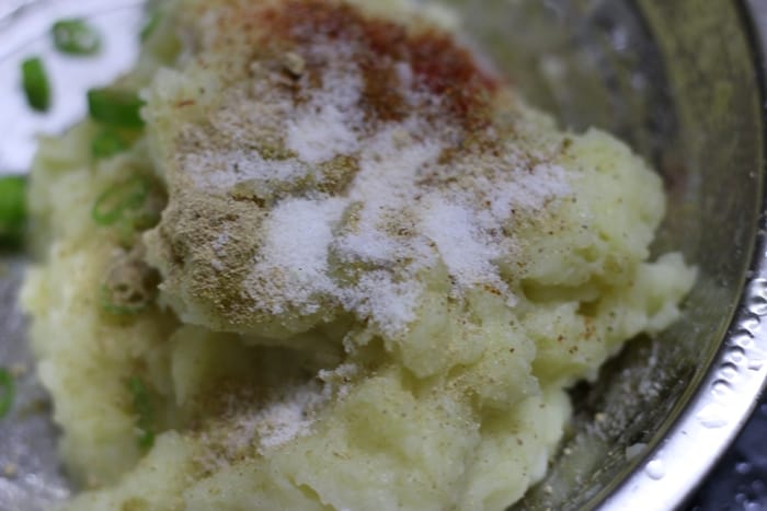 Seasoning the mashed potatoes with salt and spice powders