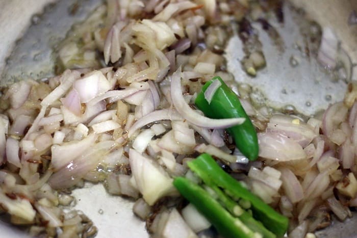 sauteing onions and green chilies in butter for making dal makhani recipe