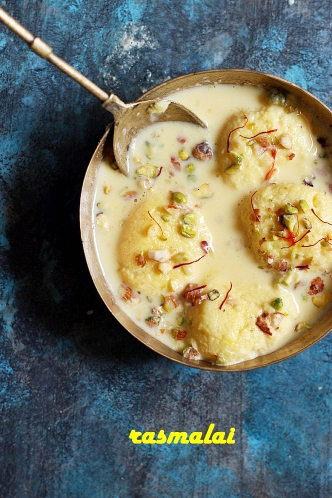 Chilled rasmalai discs served in a copper bowl with a spoon