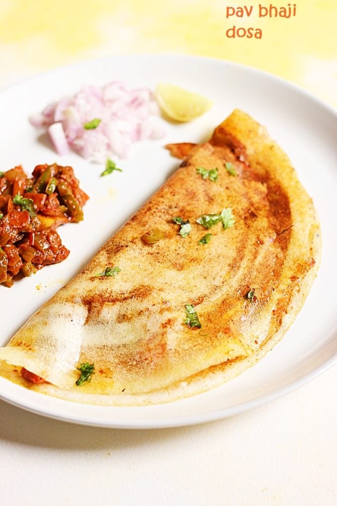 crispy pav bhaji dosa served with a side of onions and spicy bhaji