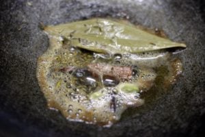 frying whole spices in butter for shahi paneer