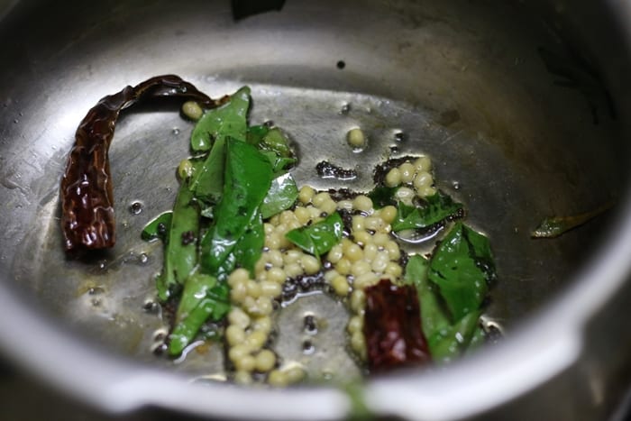 Preparing tempering for making poricha kuzhambu recipe