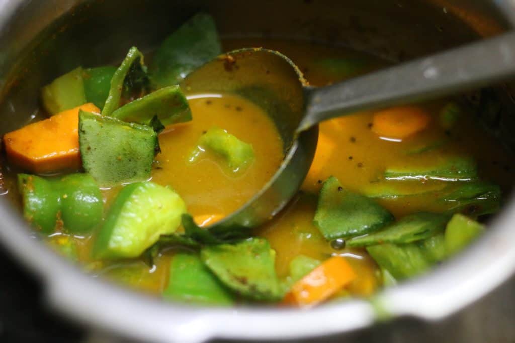 adding veggies for making poricha kuzhambu recipe