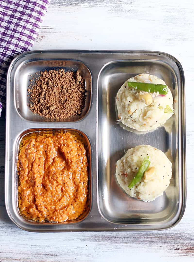 South indian rava uoma served in sectiond steel plate with sugar and chutney