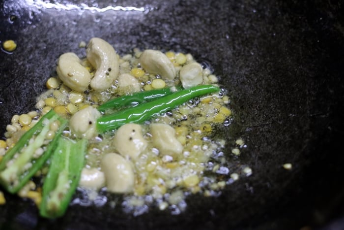 sauteing mustard seeds, chana dal curry leaves, cashews, chana dal, green chilies 