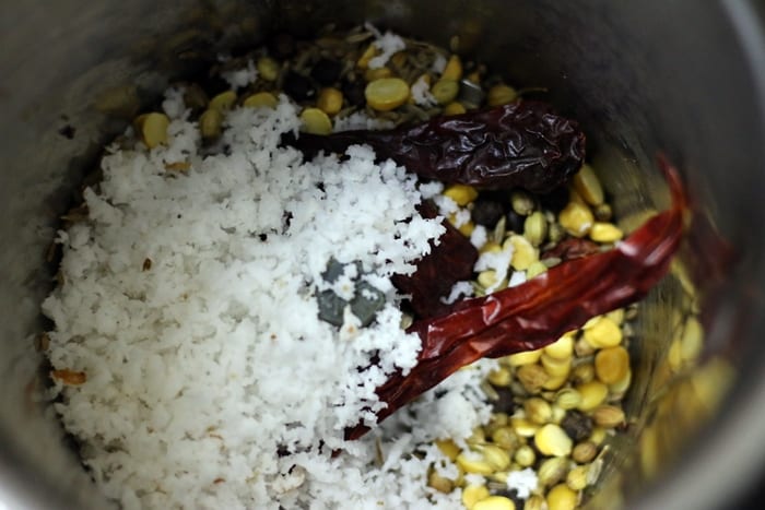 grinding roasted whole spices with freshly grated coconut.