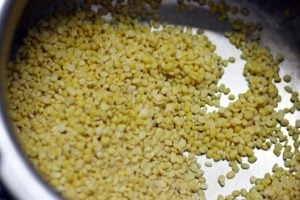 rinsed moong dal or yellow lentils for cooking in a pressure cooker