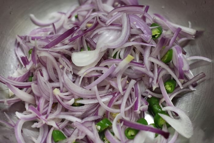 sliced onions and green chilies in a bowl
