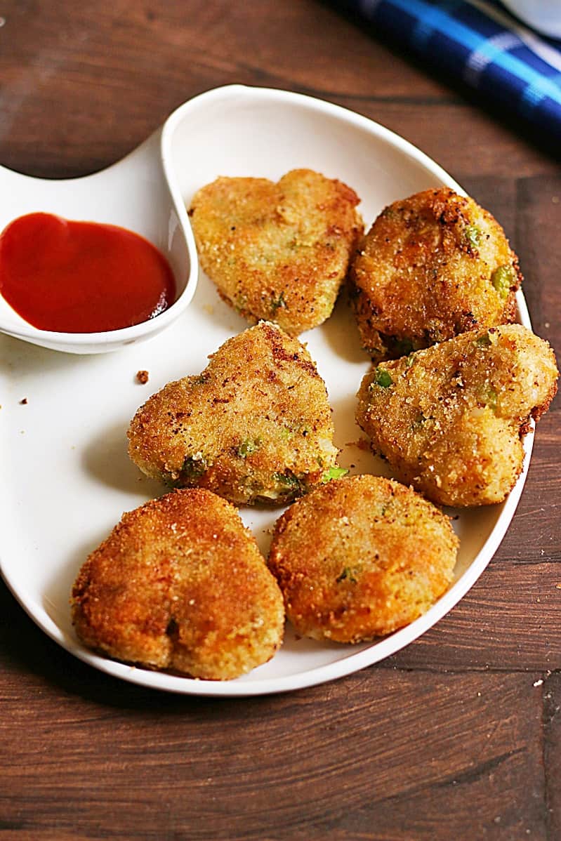 Fresh vegetable cutlets served in a chip n dip plate with ketchup