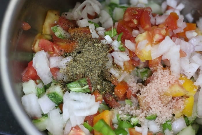 seasoning Indian onion tomato cucumber salad with salt and pepper