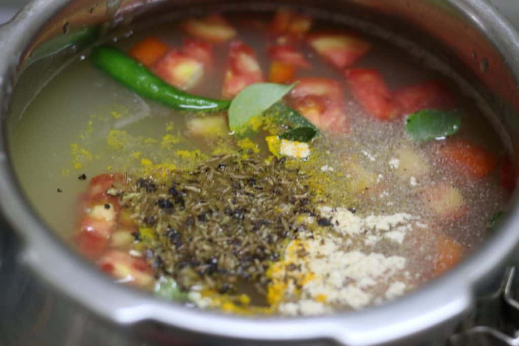 Salt, tomatoes, chilies and pepper powder added to water