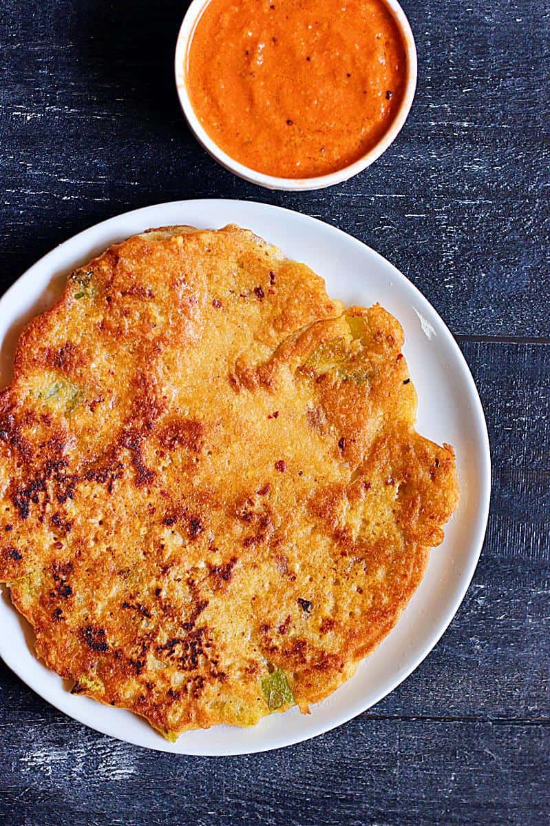 South Indian adai dosa ith tomato chutney on a white plate